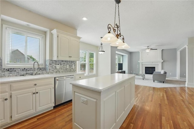 9729 Prairie Creek Rd, Lenexa, KS 66220 - kitchen featuring stainless steel dishwasher, a center island, a ceiling fan, light wood-style floors, and a textured ceiling