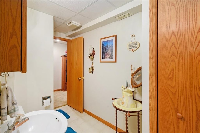 2721 SW Herefordshire Rd, Topeka, KS 66614 - bathroom with a paneled ceiling, a sink, tile patterned floors, and baseboards