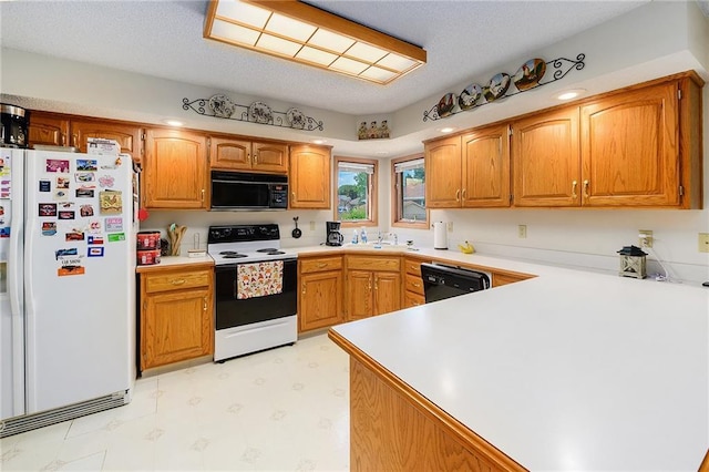 2721 SW Herefordshire Rd, Topeka, KS 66614 - kitchen with black appliances, light flooring, a peninsula, light countertops, and a sink