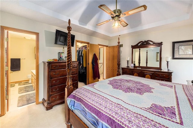 2721 SW Herefordshire Rd, Topeka, KS 66614 - bedroom with light colored carpet, a tray ceiling, a spacious closet, connected bathroom, and ceiling fan