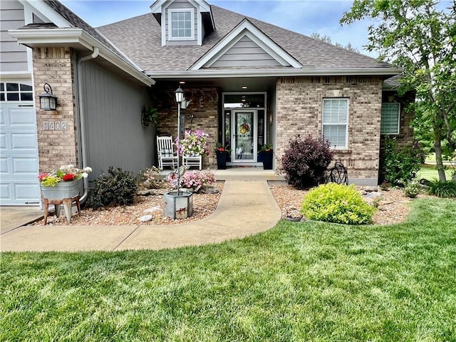 1402 NW Cedar Ct, Grain Valley, MO 64029 - view of front of home featuring a shingled roof, a front lawn, covered porch, brick siding, and a garage