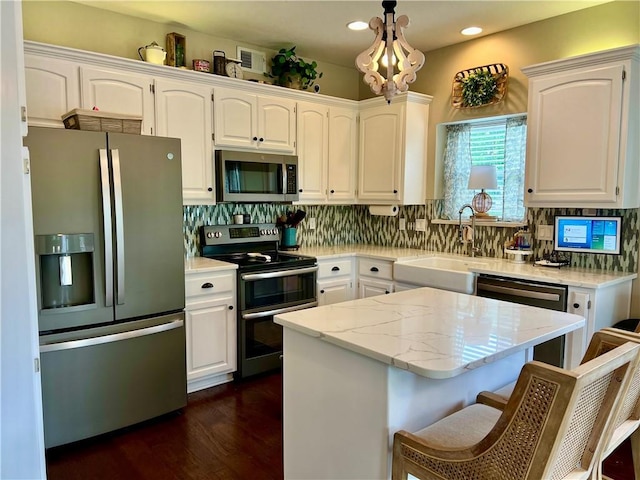 1402 NW Cedar Ct, Grain Valley, MO 64029 - kitchen featuring appliances with stainless steel finishes, a sink, white cabinets, tasteful backsplash, and recessed lighting