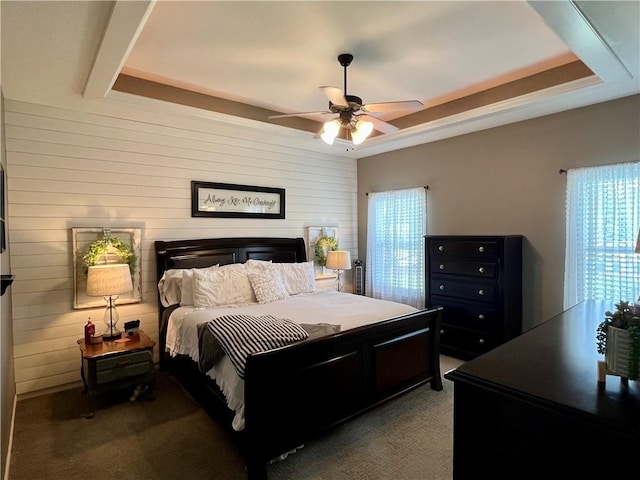 1402 NW Cedar Ct, Grain Valley, MO 64029 - bedroom with carpet, wooden walls, a tray ceiling, and ceiling fan