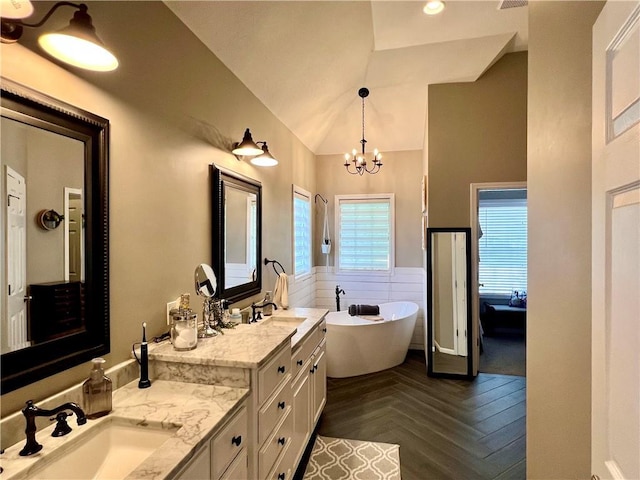 1402 NW Cedar Ct, Grain Valley, MO 64029 - bathroom with double vanity, a freestanding tub, a chandelier, and high vaulted ceiling