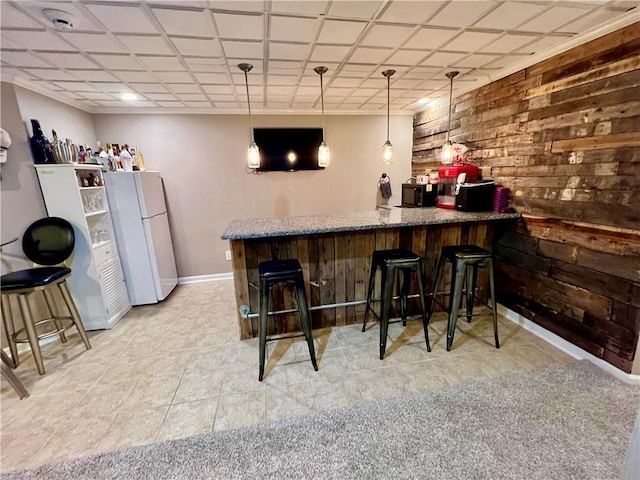 1402 NW Cedar Ct, Grain Valley, MO 64029 - indoor dry bar with freestanding refrigerator, wood walls, baseboards, and decorative light fixtures