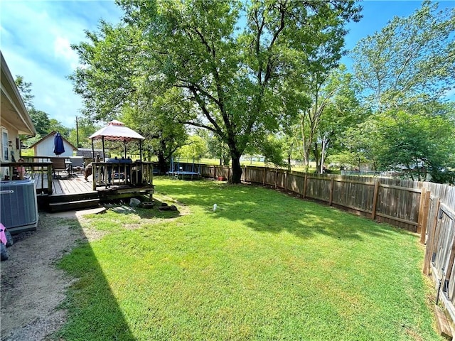 400 S 7th St, Arma, KS 66712 - view of yard featuring a gazebo, a trampoline, a wooden deck, and central AC unit