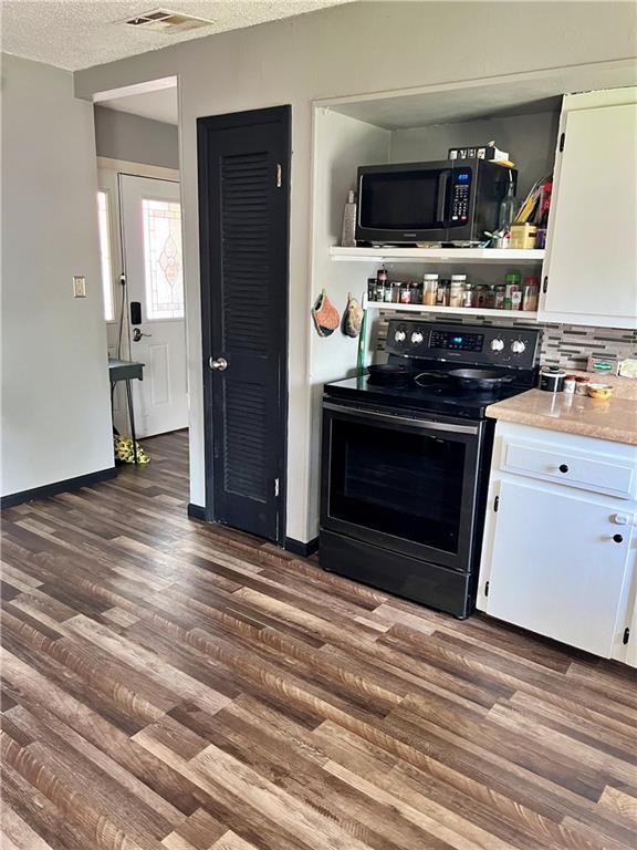 400 S 7th St, Arma, KS 66712 - kitchen featuring electric stove, white cabinets, dark wood-style flooring, a textured ceiling, and light countertops