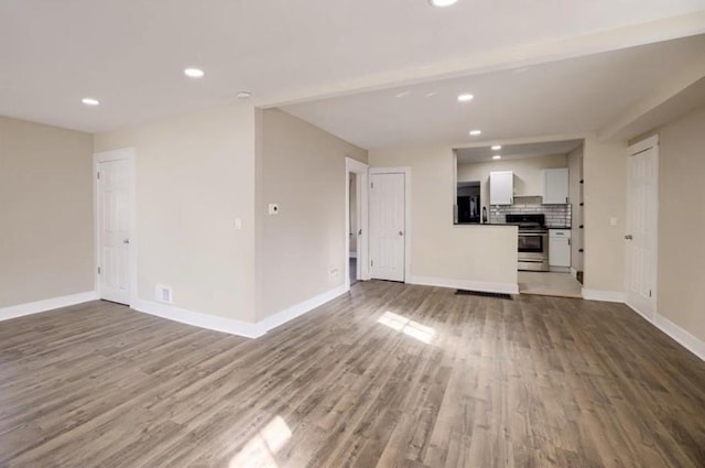 4204 E 60th Ter, Kansas City, MO 64130 - unfurnished living room with wood finished floors, baseboards, and recessed lighting