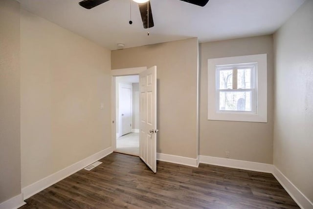 4204 E 60th Ter, Kansas City, MO 64130 - unfurnished bedroom featuring dark wood-style floors, baseboards, and ceiling fan