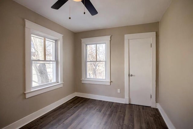 4204 E 60th Ter, Kansas City, MO 64130 - spare room with a ceiling fan, dark wood-style floors, and baseboards