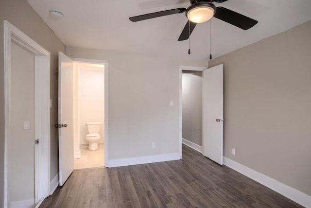 4204 E 60th Ter, Kansas City, MO 64130 - unfurnished bedroom with wood finished floors, baseboards, connected bathroom, and ceiling fan
