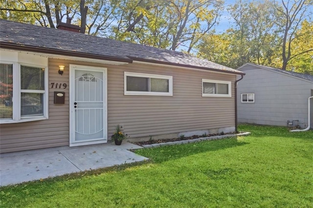 7119 E 111th Ter, Kansas City, MO 64134 - view of exterior entry featuring a yard and a chimney