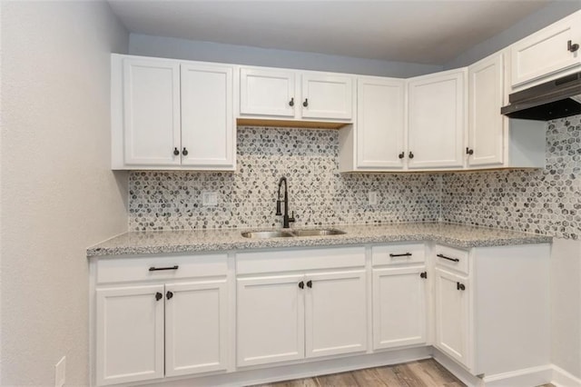 7119 E 111th Ter, Kansas City, MO 64134 - kitchen with a sink, range hood, light stone countertops, and white cabinets