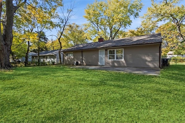 7119 E 111th Ter, Kansas City, MO 64134 - back of house with a chimney and a patio area