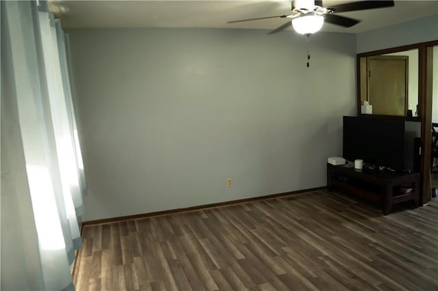 1015 S Elm St, Ottawa, KS 66067 - unfurnished living room featuring a ceiling fan, dark wood finished floors, and baseboards