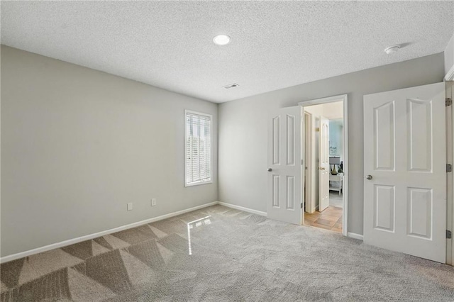 7407 W 145th Ter, Overland Park, KS 66223 - unfurnished bedroom featuring carpet floors, a textured ceiling, and baseboards