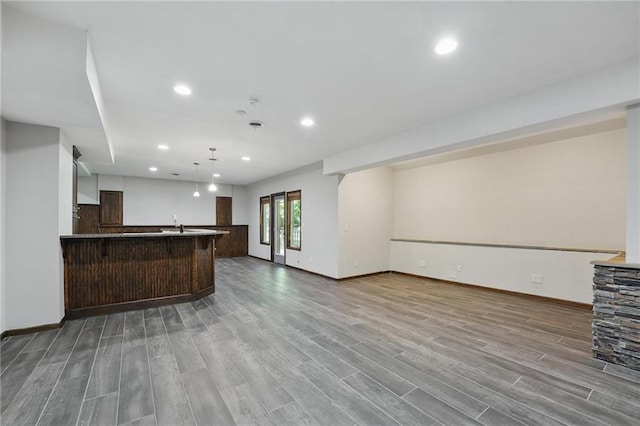 7407 W 145th Ter, Overland Park, KS 66223 - unfurnished living room featuring wood finished floors, baseboards, recessed lighting, and bar area