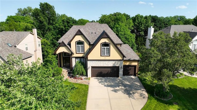 7407 W 145th Ter, Overland Park, KS 66223 - view of front facade featuring stone siding, stucco siding, driveway, and a front yard