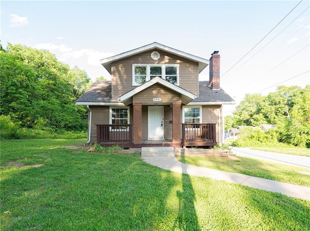 4941 Park Ave, Kansas City, MO 64130 - view of front of home with a chimney, a front yard, a porch, and a shingled roof