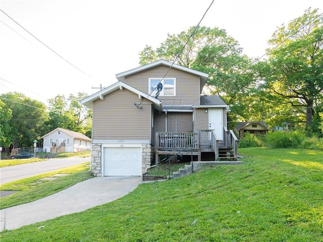 4941 Park Ave, Kansas City, MO 64130 - view of front of home with concrete driveway, an attached garage, a front yard, stone siding, and a deck