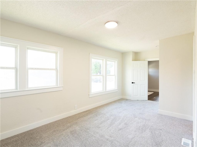 4941 Park Ave, Kansas City, MO 64130 - carpeted spare room with baseboards and a textured ceiling