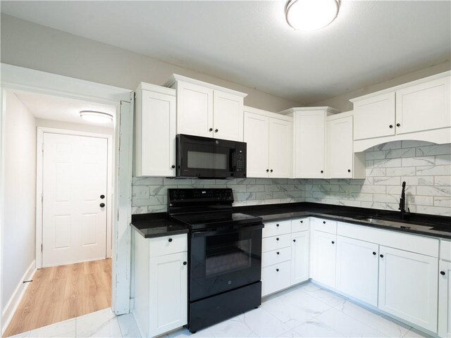 4941 Park Ave, Kansas City, MO 64130 - kitchen featuring black appliances, a sink, white cabinets, tasteful backsplash, and dark countertops