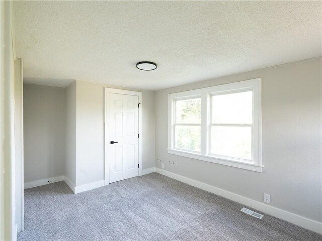4941 Park Ave, Kansas City, MO 64130 - unfurnished bedroom featuring baseboards, carpet flooring, a textured ceiling, and a closet