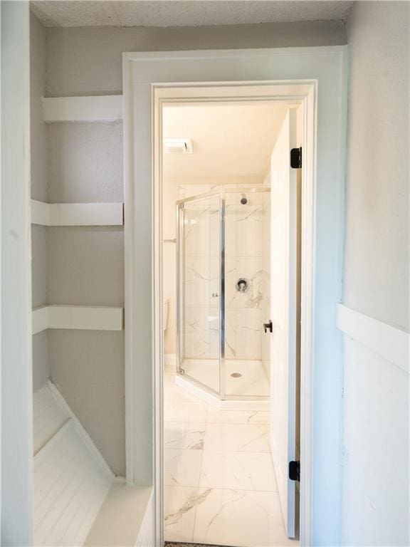 4941 Park Ave, Kansas City, MO 64130 - bathroom with marble look tile flooring and a stall shower