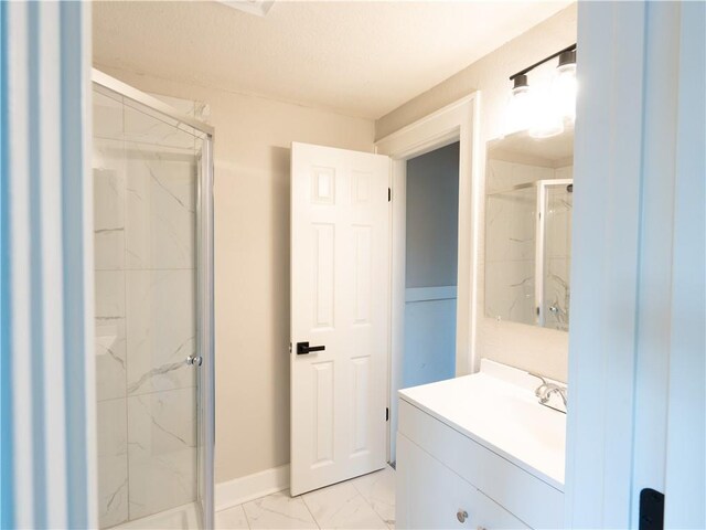 4941 Park Ave, Kansas City, MO 64130 - bathroom featuring marble finish floors, a marble finish shower, vanity, and baseboards