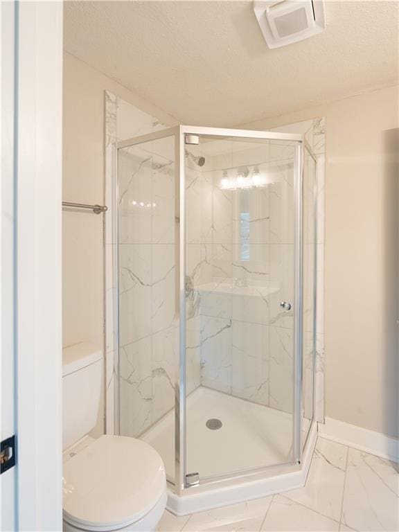 4941 Park Ave, Kansas City, MO 64130 - bathroom with toilet, a marble finish shower, baseboards, and a textured ceiling