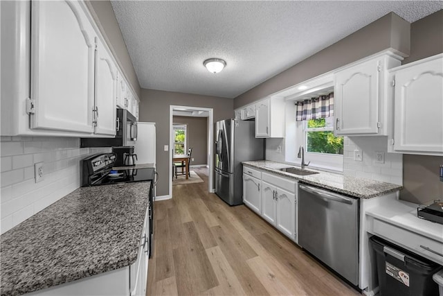 1728 SE 7th Ter, Lees Summit, MO 64063 - kitchen featuring stainless steel appliances, a sink, white cabinets, healthy amount of natural light, and a textured ceiling