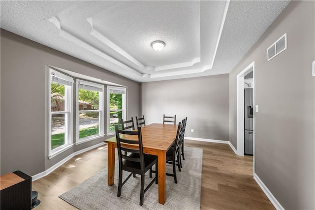 1728 SE 7th Ter, Lees Summit, MO 64063 - dining area with a textured ceiling, a raised ceiling, baseboards, and wood finished floors