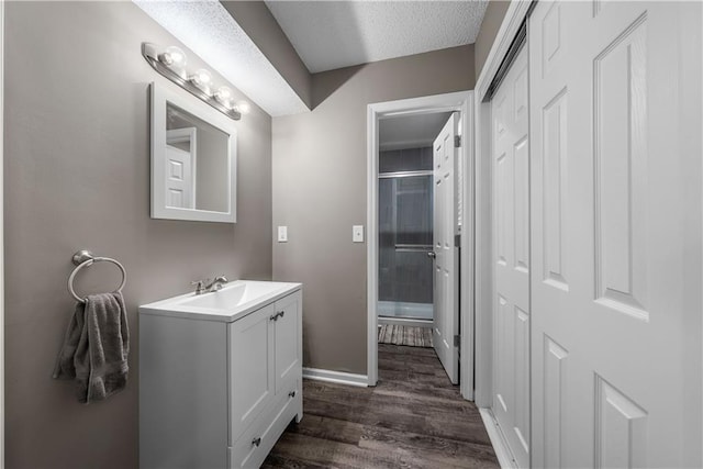 1728 SE 7th Ter, Lees Summit, MO 64063 - bathroom with vanity, wood finished floors, an enclosed shower, baseboards, and a textured ceiling
