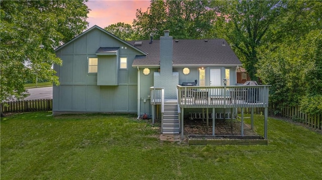1728 SE 7th Ter, Lees Summit, MO 64063 - back of property at dusk with a wooden deck, stairs, a chimney, and roof with shingles