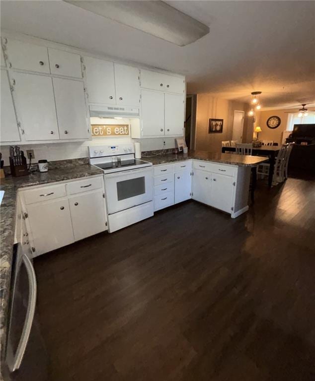 611 W Main St, Chanute, KS 66720 - kitchen featuring white range with electric stovetop, a peninsula, under cabinet range hood, dark wood-type flooring, and dark countertops