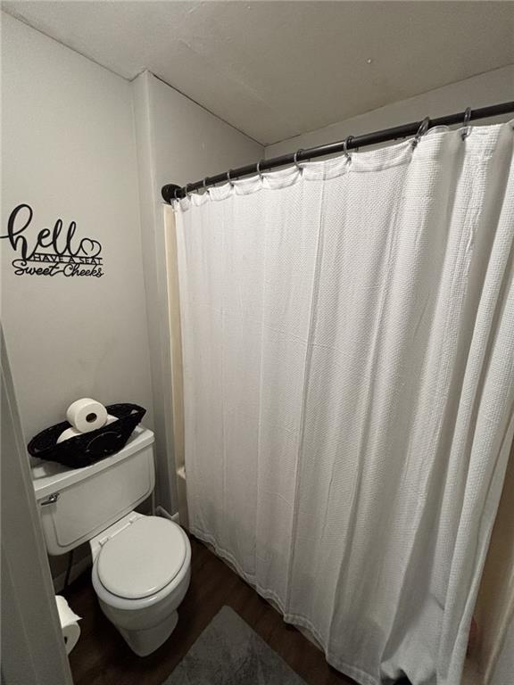 611 W Main St, Chanute, KS 66720 - bathroom featuring toilet and wood finished floors