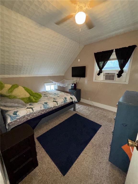 611 W Main St, Chanute, KS 66720 - carpeted bedroom with baseboards, vaulted ceiling, and a ceiling fan