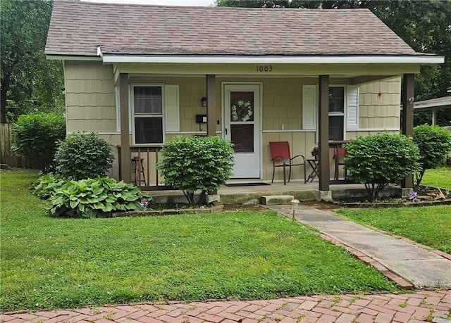 1003 W 3rd St, Pittsburg, KS 66762 - bungalow-style house featuring a porch, a shingled roof, and a front lawn