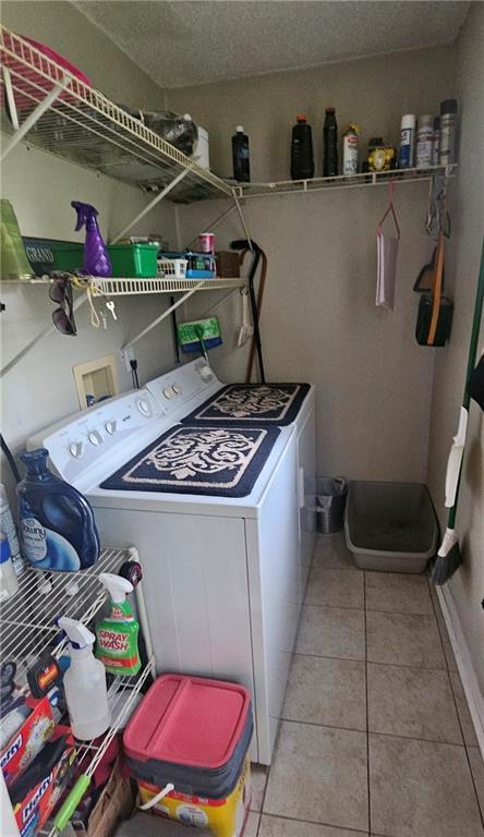 1003 W 3rd St, Pittsburg, KS 66762 - laundry room with washing machine and dryer and light tile patterned flooring