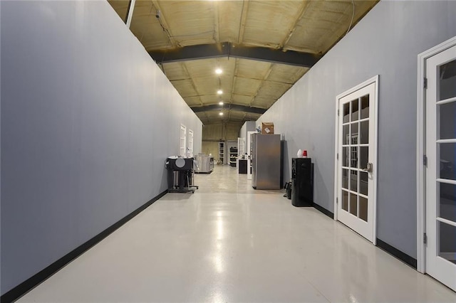 411 E 203rd St, Belton, MO 64012 - hall with french doors, lofted ceiling, finished concrete flooring, and baseboards