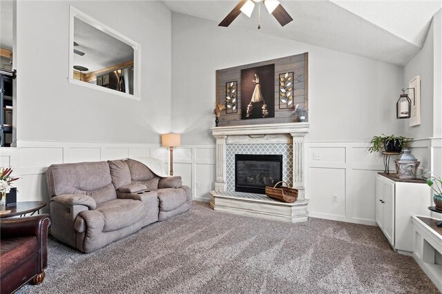 8801 NE 116th St, Kansas City, MO 64157 - carpeted living area featuring a ceiling fan, lofted ceiling, a decorative wall, a tiled fireplace, and a wainscoted wall