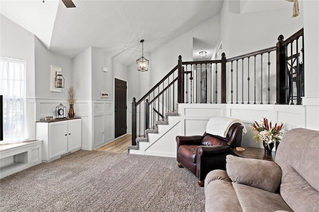 8801 NE 116th St, Kansas City, MO 64157 - living area with light colored carpet, stairs, a wainscoted wall, ceiling fan, and lofted ceiling