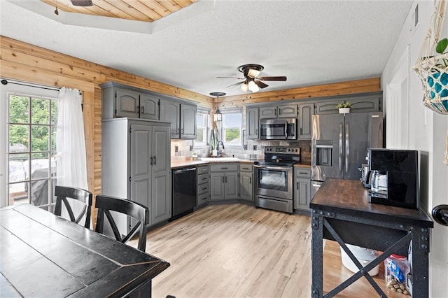 8801 NE 116th St, Kansas City, MO 64157 - kitchen with stainless steel appliances, ceiling fan, gray cabinets, tasteful backsplash, and light wood-type flooring