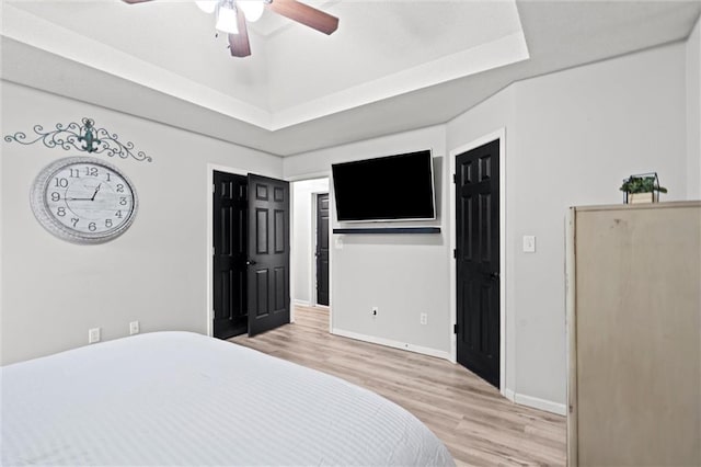 8801 NE 116th St, Kansas City, MO 64157 - bedroom featuring light wood-style flooring, a raised ceiling, and a ceiling fan