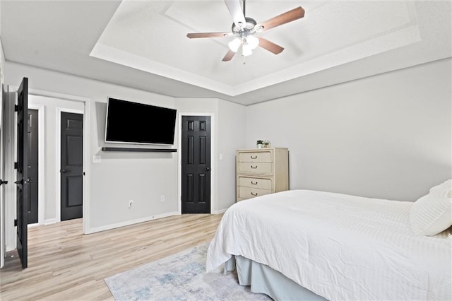 8801 NE 116th St, Kansas City, MO 64157 - bedroom with a tray ceiling, light wood-style flooring, and a ceiling fan