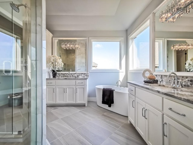 3248 W 133rd Ter, Leawood, KS 66209 - bathroom featuring two vanities, a shower stall, a chandelier, a soaking tub, and plenty of natural light