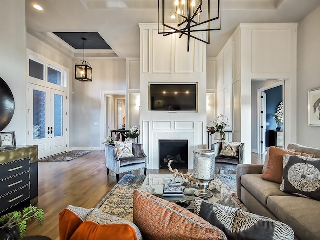 3248 W 133rd Ter, Leawood, KS 66209 - living area with dark wood-style floors, a high ceiling, a chandelier, a fireplace, and a tray ceiling