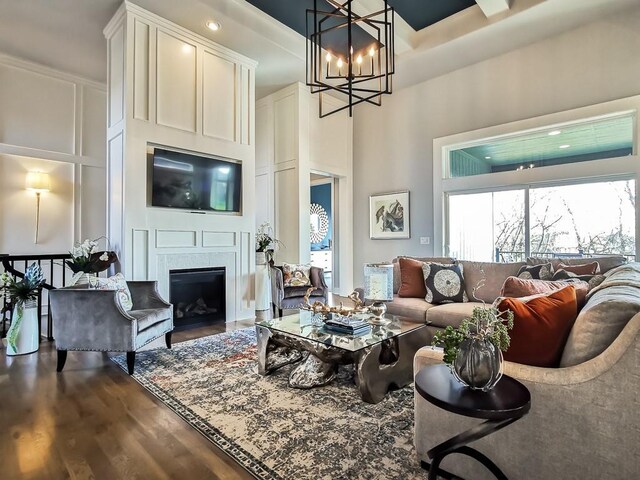 3248 W 133rd Ter, Leawood, KS 66209 - living area with wood finished floors, a chandelier, a fireplace, and a high ceiling