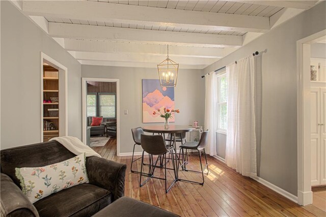 601 NW 41st St, Kansas City, MO 64116 - dining area with healthy amount of natural light, a chandelier, light wood finished floors, and wood ceiling with exposed beams