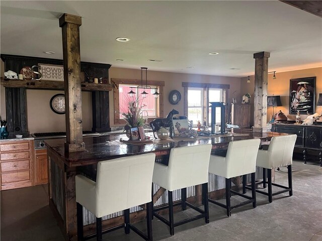 25332 E 250th Ave, Ridgeway, MO 64481 - kitchen with a kitchen breakfast bar, decorative columns, dark countertops, finished concrete flooring, and recessed lighting